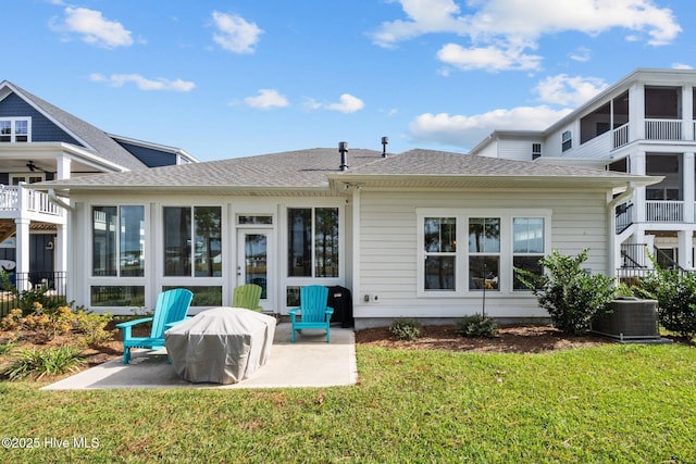 rear view of property with a lawn, central air condition unit, and a patio area