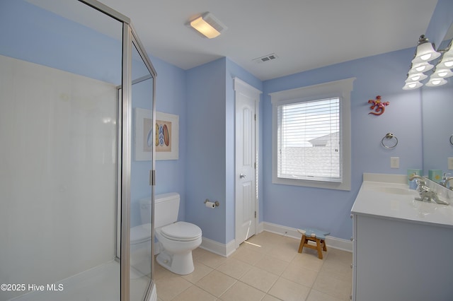 bathroom featuring tile patterned flooring, vanity, toilet, and walk in shower