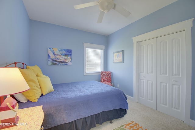 carpeted bedroom with ceiling fan and a closet