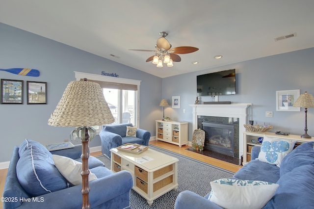 living room featuring ceiling fan, lofted ceiling, a fireplace, and hardwood / wood-style floors