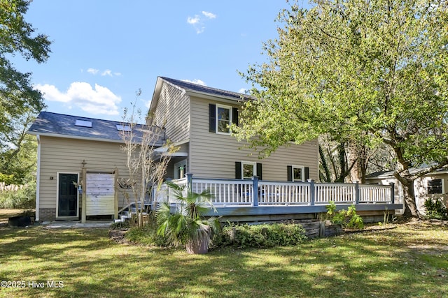 back of house featuring a deck and a lawn