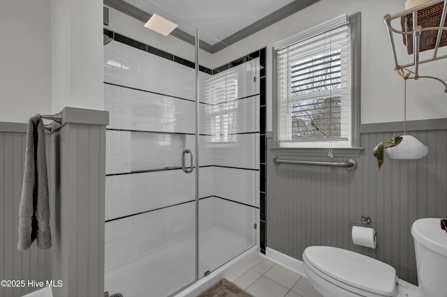 bathroom with toilet, an enclosed shower, and tile patterned flooring