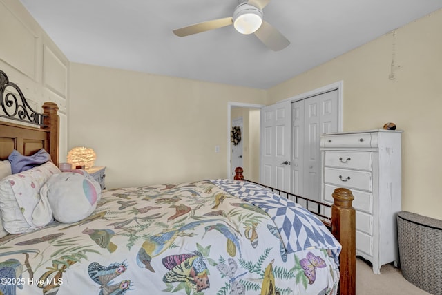 bedroom with ceiling fan, a closet, and light carpet