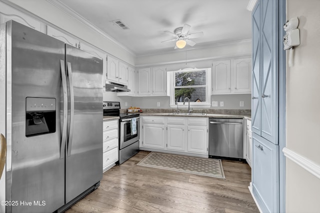 kitchen with white cabinetry, appliances with stainless steel finishes, ornamental molding, and sink