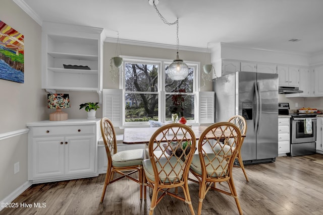 dining room featuring ornamental molding, breakfast area, and hardwood / wood-style floors