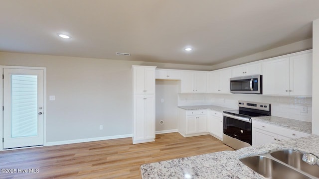 104 Bethany Pl, Goldsboro, NC 27530 - kitchen with white cabinetry, appliances with stainless steel finishes, sink, and light stone counters