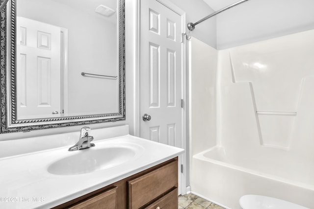 full bathroom featuring washtub / shower combination, vanity, toilet, and tile patterned flooring