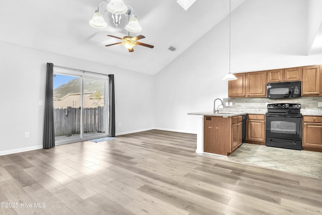 kitchen featuring kitchen peninsula, sink, light hardwood / wood-style flooring, and black appliances