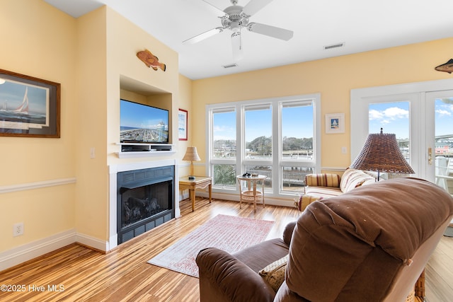 living room featuring ceiling fan and light hardwood / wood-style floors