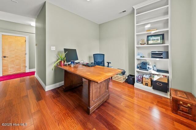 22327 NC Highway 55, Oriental, NC 28571 - home office featuring built in shelves and hardwood / wood-style floors