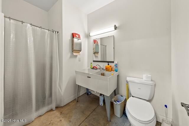 22327 NC Highway 55, Oriental, NC 28571 - bathroom featuring toilet, concrete flooring, and a shower with shower curtain