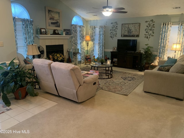 carpeted living room featuring ceiling fan, lofted ceiling, and a fireplace