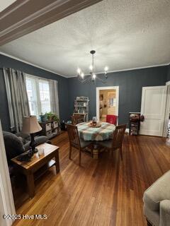 dining space with a chandelier, hardwood / wood-style floors, and a textured ceiling