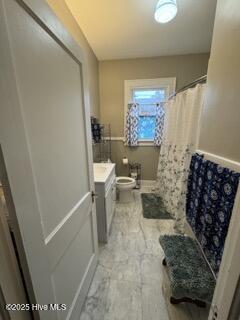 bathroom featuring vanity, toilet, and a shower with shower curtain