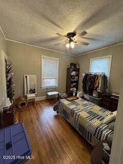 bedroom featuring ceiling fan, crown molding, dark hardwood / wood-style floors, and a textured ceiling