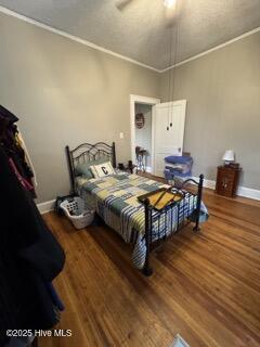 bedroom featuring dark wood-type flooring and ornamental molding