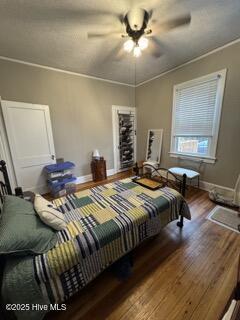 bedroom featuring wood-type flooring, ceiling fan, and crown molding