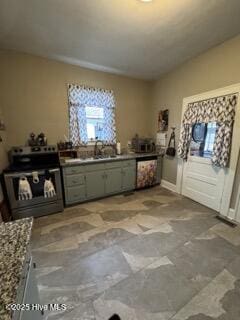 interior space featuring sink, a wealth of natural light, stainless steel range with electric cooktop, and dishwasher