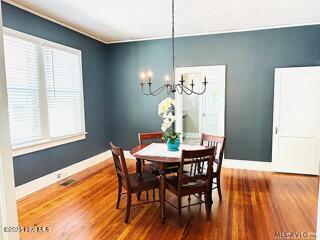 dining space featuring wood-type flooring and a notable chandelier