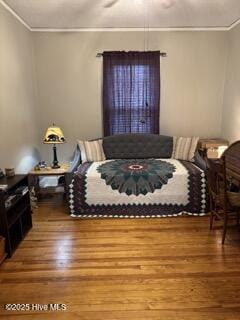 bedroom featuring ornamental molding and hardwood / wood-style floors