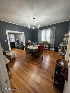 dining space featuring hardwood / wood-style floors, a notable chandelier, and a textured ceiling