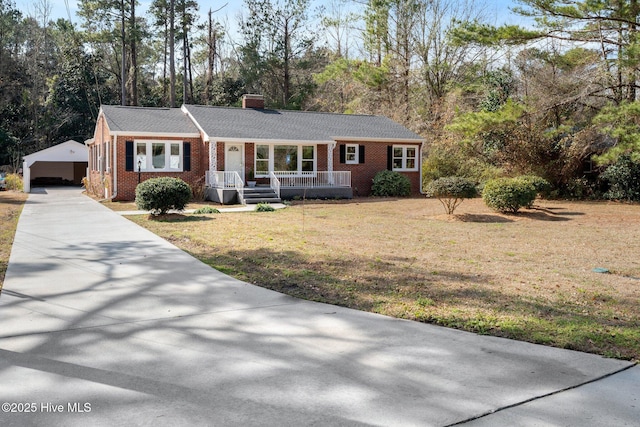 single story home with an outbuilding, a garage, and a front yard