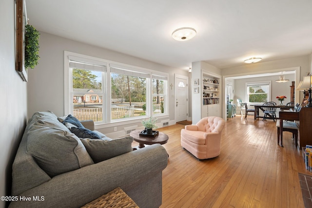 living room with hardwood / wood-style floors and built in shelves