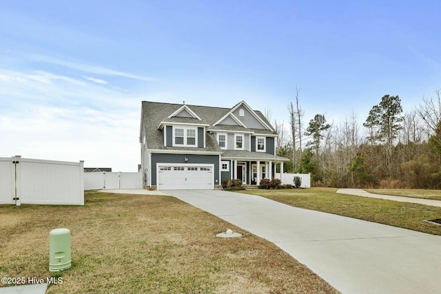 view of front of property featuring a garage, covered porch, and a front lawn