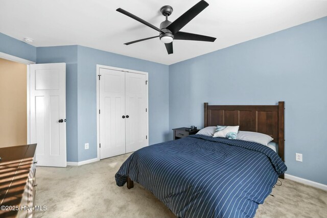 carpeted bedroom featuring ceiling fan and a closet