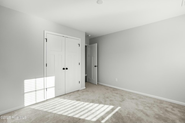 unfurnished bedroom featuring a closet and light carpet