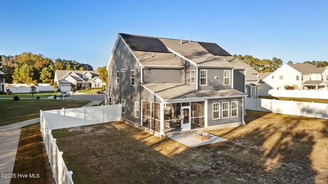 back of house with a patio, a sunroom, and a lawn