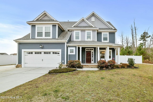 view of front of house with a garage, a front yard, and covered porch