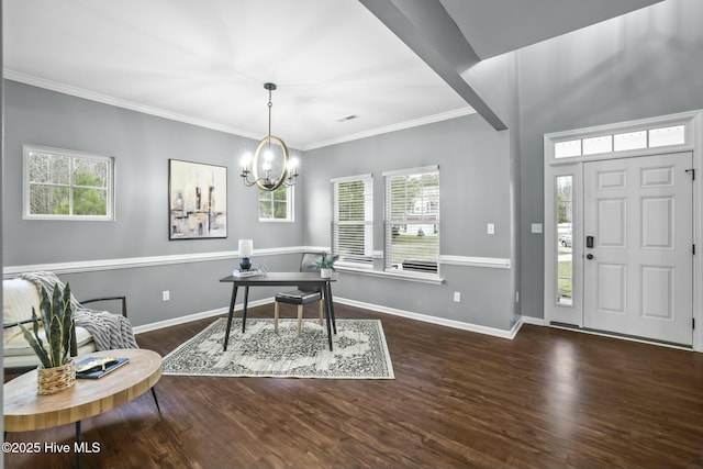 foyer entrance featuring ornamental molding, dark wood-type flooring, and a chandelier