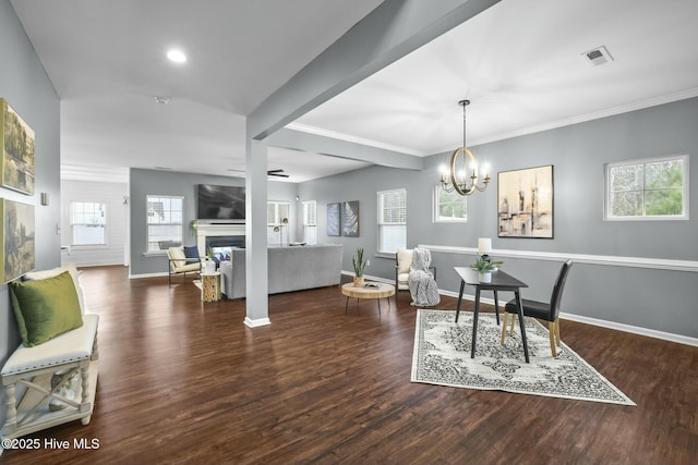 dining area with dark wood-type flooring, ornamental molding, and plenty of natural light