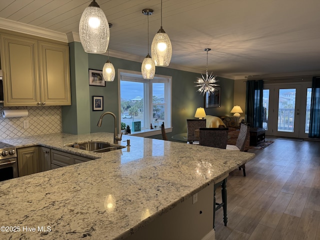 kitchen featuring sink, ornamental molding, and hanging light fixtures