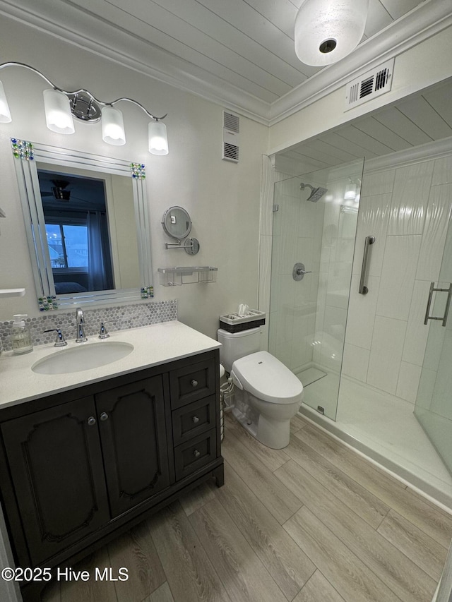 bathroom with toilet, an enclosed shower, crown molding, vanity, and hardwood / wood-style floors