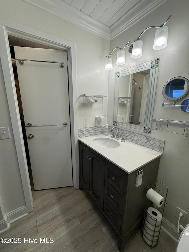 bathroom featuring hardwood / wood-style flooring, ornamental molding, and vanity