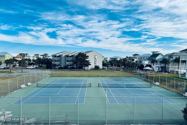 view of tennis court featuring a yard