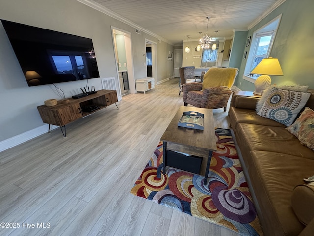 living room featuring ornamental molding, a notable chandelier, and light hardwood / wood-style flooring