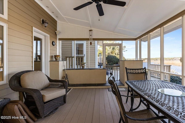 sunroom featuring a wealth of natural light, a water view, vaulted ceiling, and ceiling fan