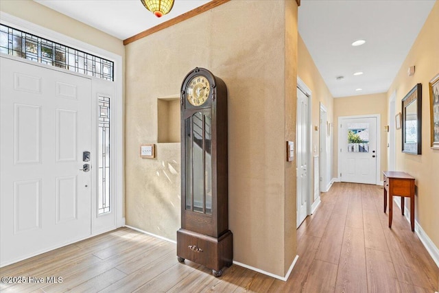 foyer featuring baseboards, wood finished floors, and recessed lighting