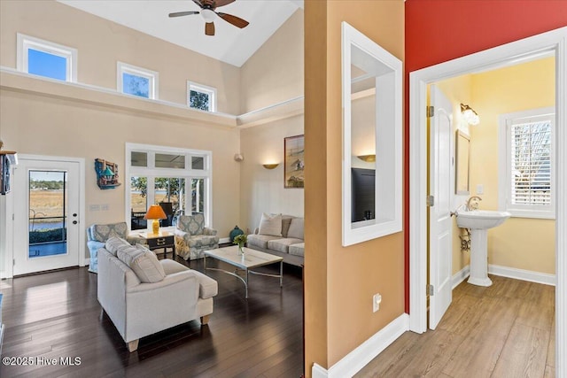 living area featuring a ceiling fan, wood finished floors, and a healthy amount of sunlight