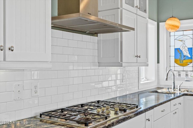 kitchen with extractor fan, a sink, white cabinets, and stainless steel gas stovetop