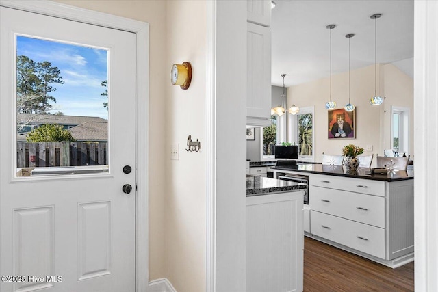 kitchen with hanging light fixtures, a chandelier, white cabinets, and dark wood finished floors