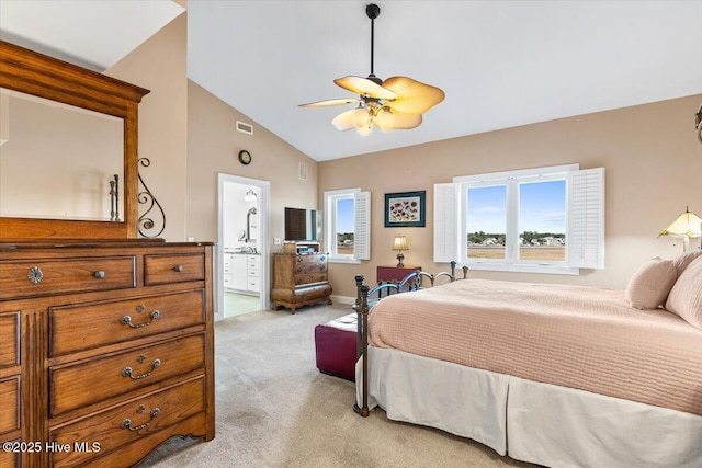 bedroom with lofted ceiling, light carpet, visible vents, a ceiling fan, and ensuite bath