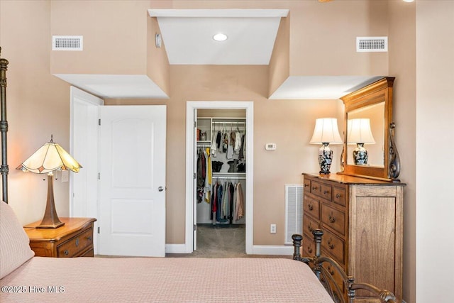 bedroom featuring carpet, a spacious closet, and visible vents