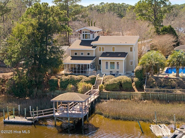 exterior space with a water view, a sunroom, and fence