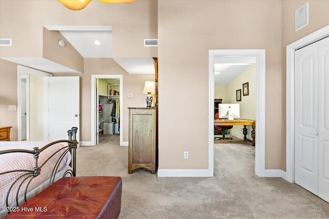 bedroom featuring light carpet, baseboards, visible vents, and a closet