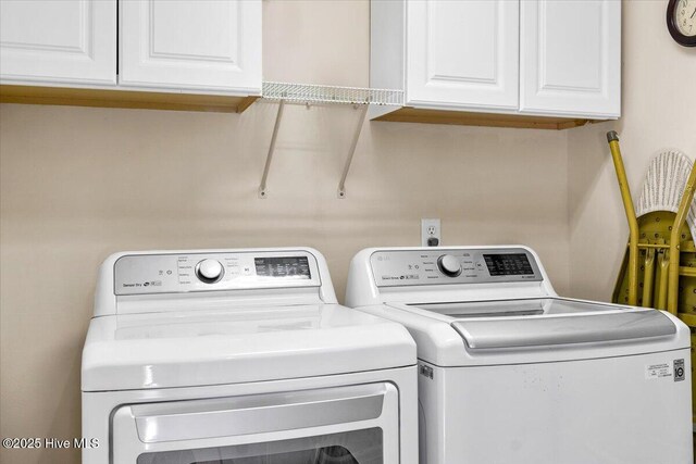 laundry area with independent washer and dryer and cabinet space