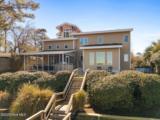 back of house with a sunroom and stairway